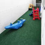 Área externa de lazer com brinquedos como gangorra, escorregador dentre outros brinquedos no Berçário do Colégio Mirassol.